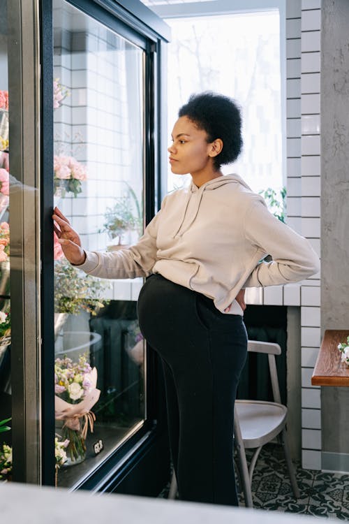 A Pregnant Woman Standing Inside a Flower Shop