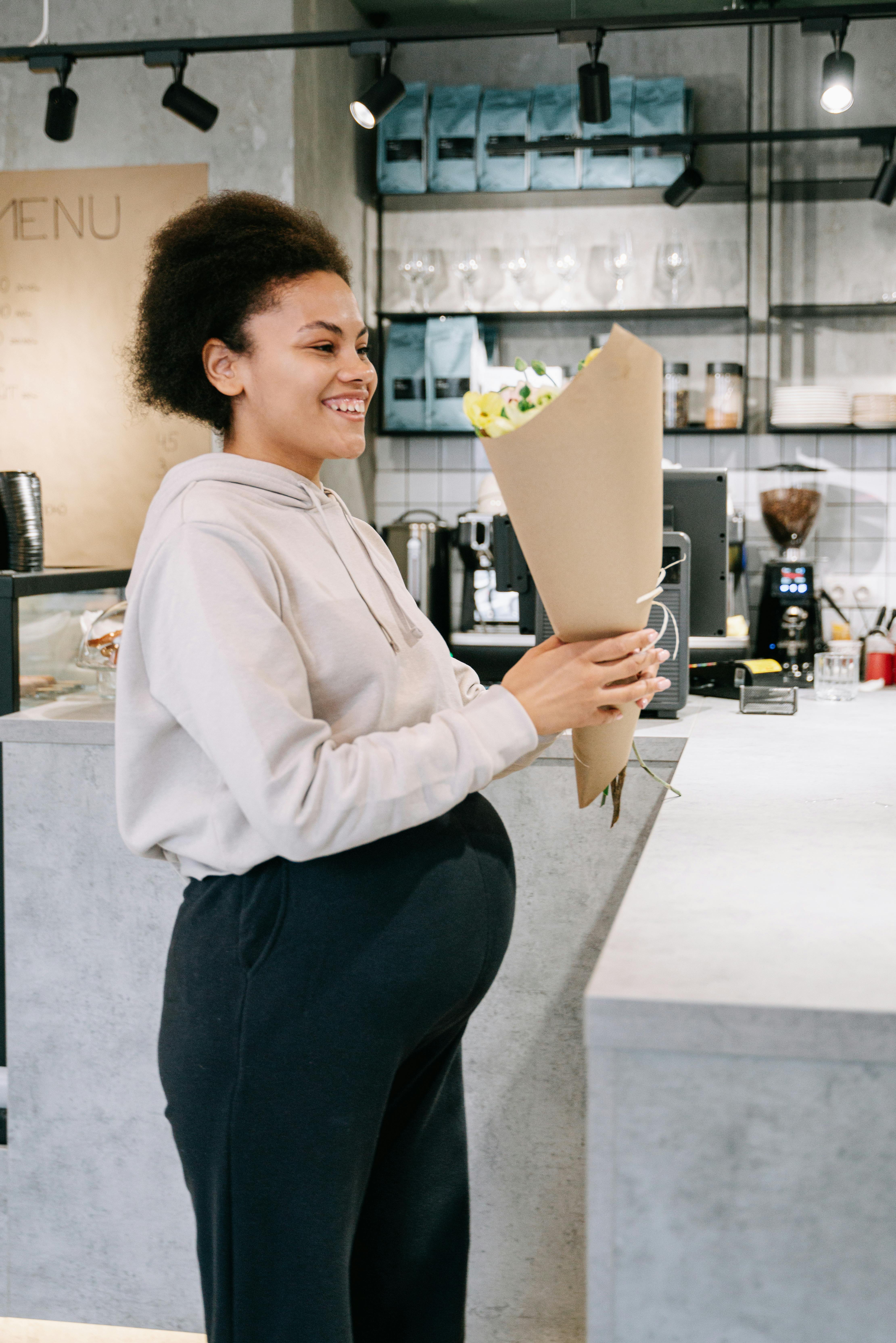 pregnant woman holding bouquet and smiling