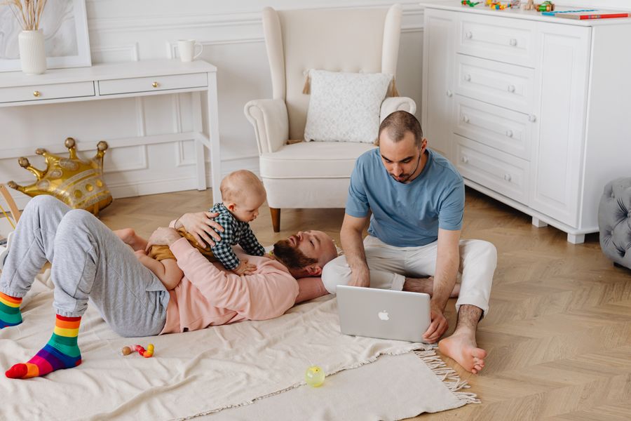 A family using a laptop together in a bright living room