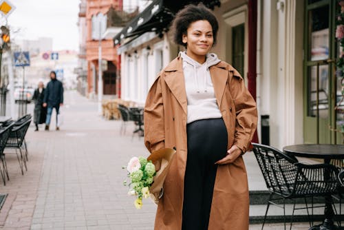 A Pregnant Woman Holding Bouquet of Flowers