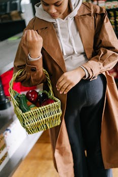 Stylish pregnant woman shopping for fresh groceries in a store during fall.