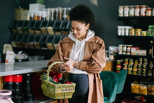 Free A pregnant woman shops for fresh vegetables at an organic grocery store. Stock Photo