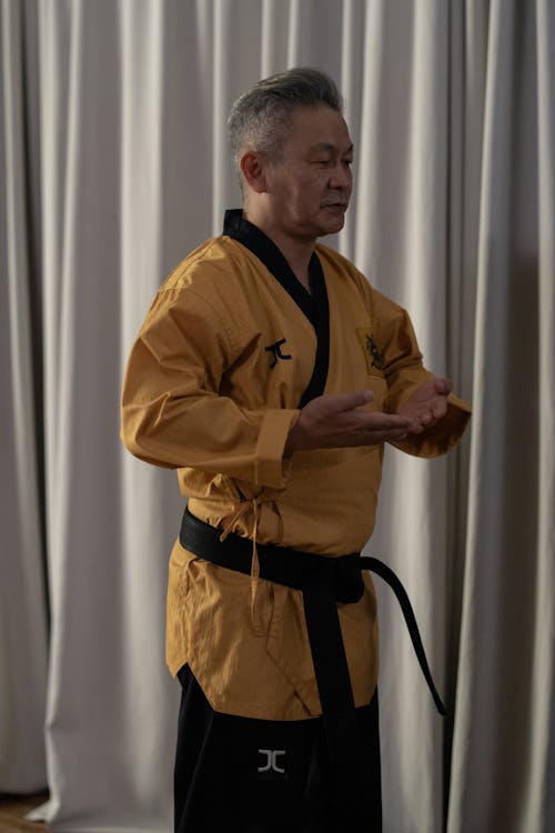 Man in Yellow Kimono Holding Hands in Front