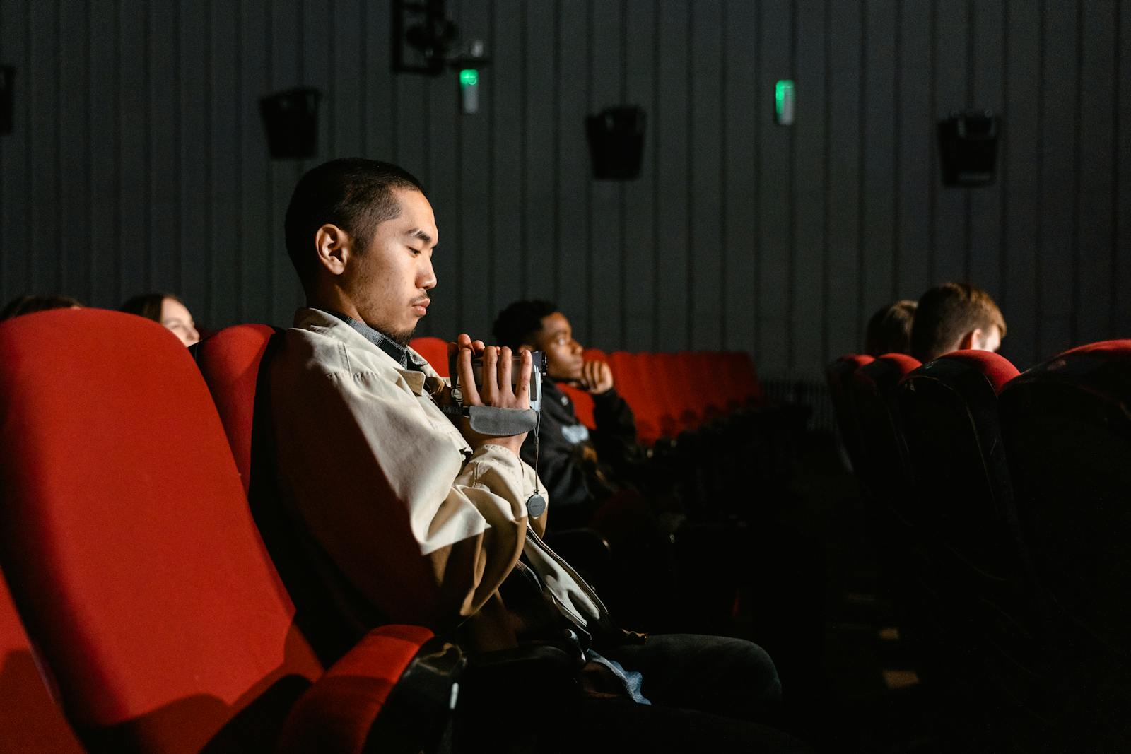 Audience in a dark cinema watching a film on the big screen