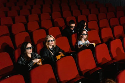 People Eating Popcorn and Wearing 3D Glasses