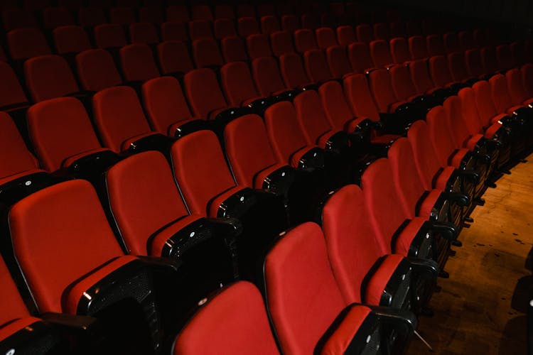 Red And Black Empty Folded Chairs In An Auditorium