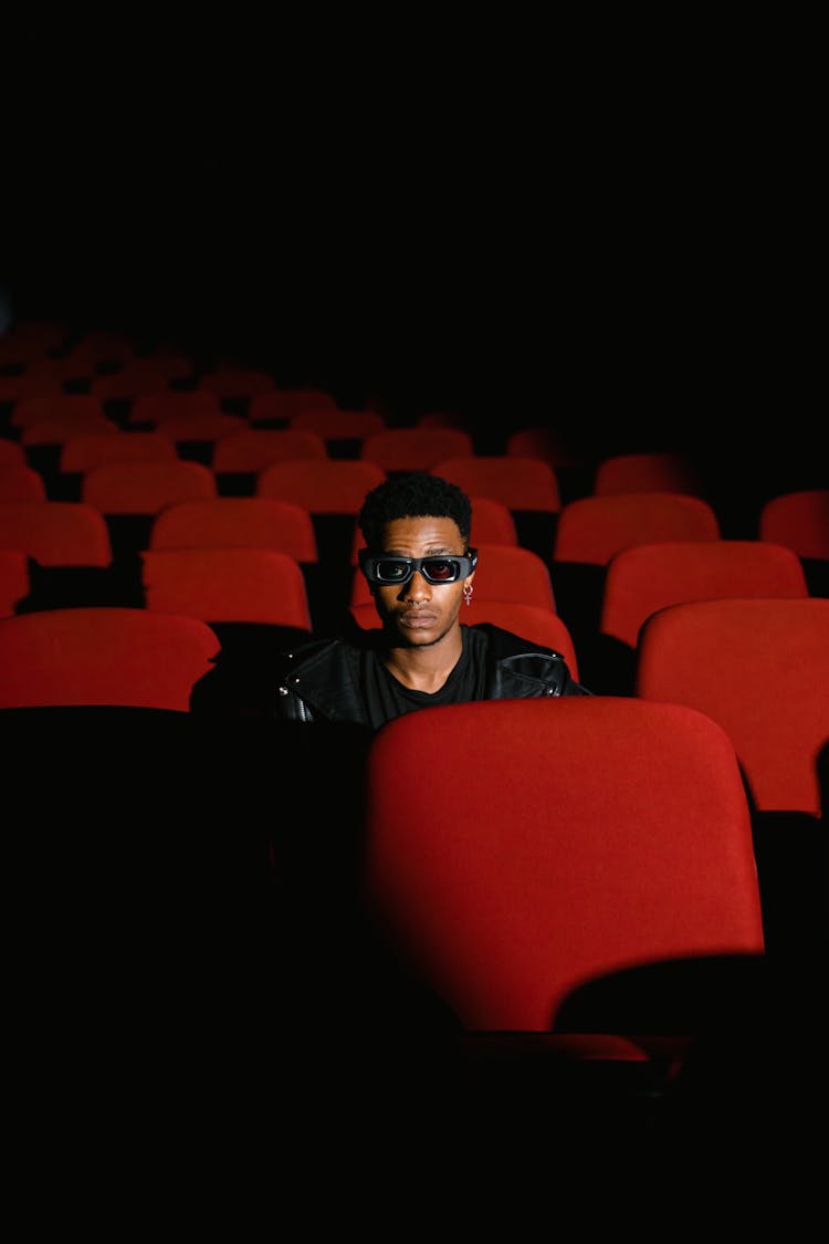 Man Wearing 3D Glasses Sitting In Empty Movie Theatre 