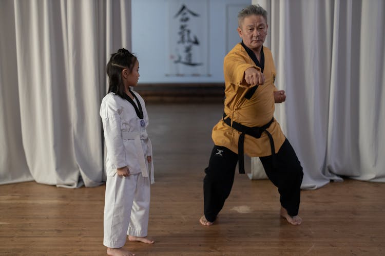 A Senior Man Teaching A Girl Karate