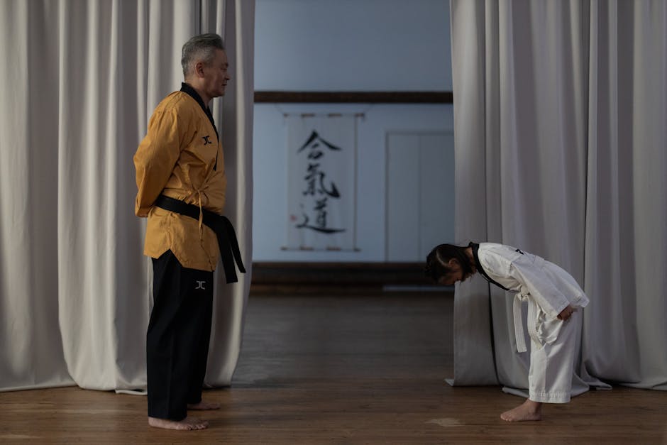 A Girl Bowing in Front of a Karate Teacher
