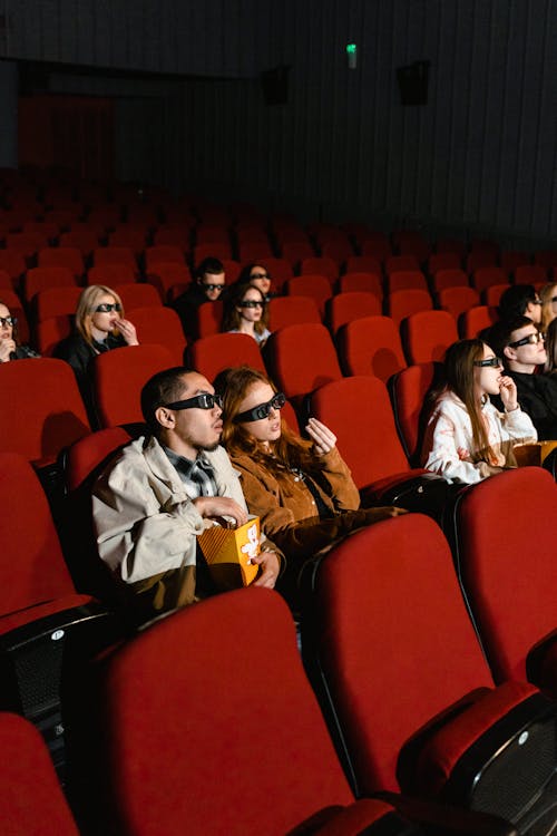 People Eating Popcorn and Wearing 3D Glasses
