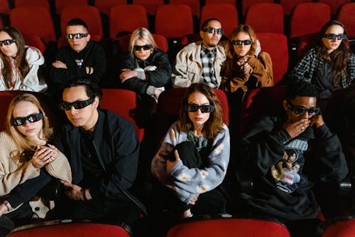 People Wearing 3D Glasses while Watching a Movie