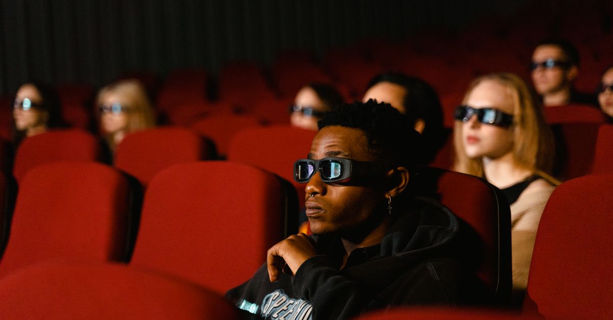 Movie theater audience watching a superhero film with bored expressions