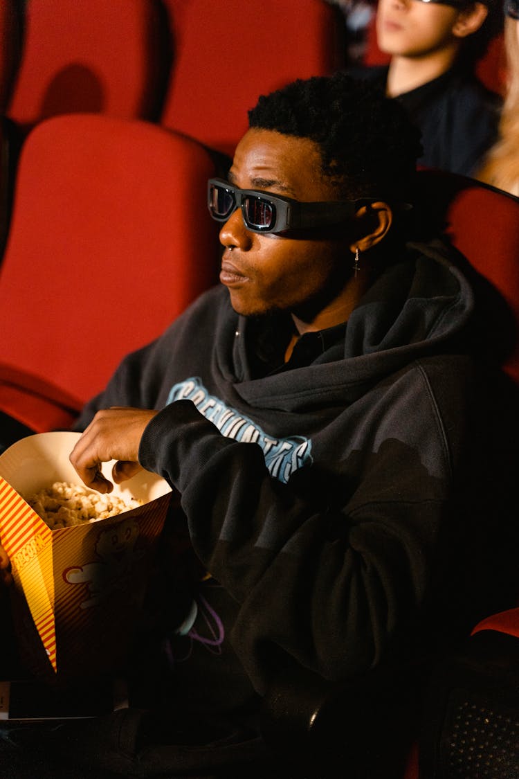 A  Man Watching In A 3d Cinema With Popcorn