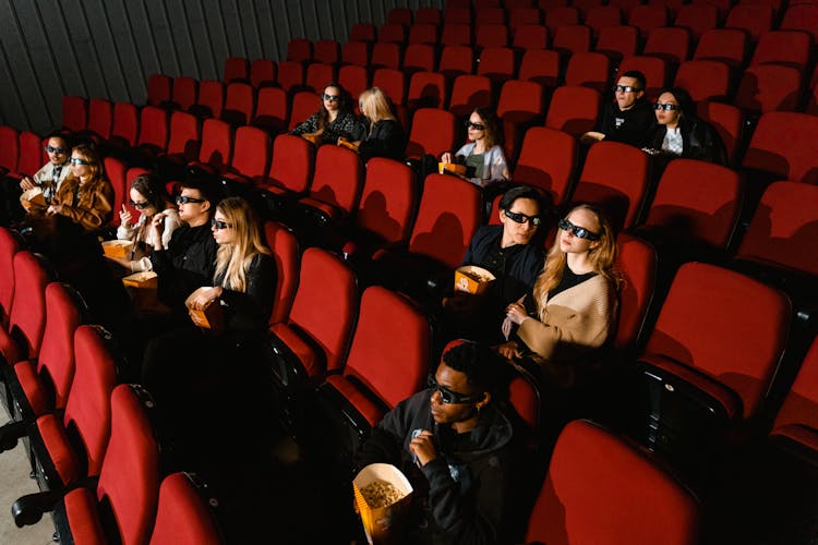 People Eating Popcorn And Wearing 3D Glasses