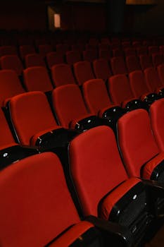 Empty theater with rows of red seats, creating a dramatic ambiance.