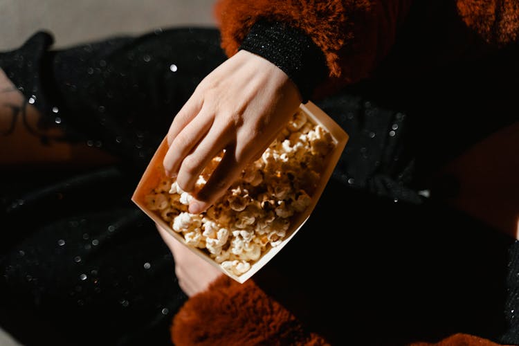 A Person Eating A Popcorn