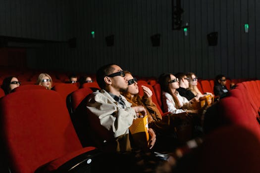 People watching a 3D movie in a theater, with popcorn in hand, fully immersed.