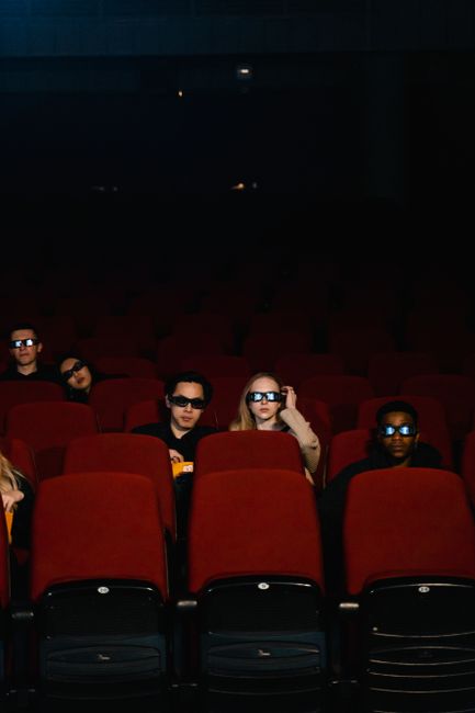 Group of people in 3D glasses enjoying a movie at a cinema