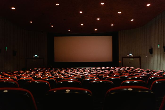 Empty cinema auditorium with red seats facing a lit screen — photo by Tima Miroshnichenko on Pexels