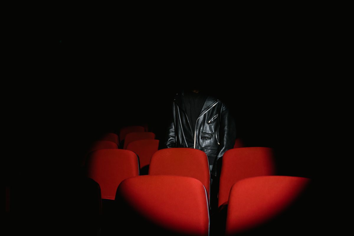 Crowd entering a modern cinema with bright posters