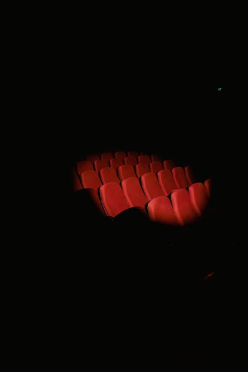 Бесплатное стоковое фото с вертикальный выстрел, красные стулья, прожектор