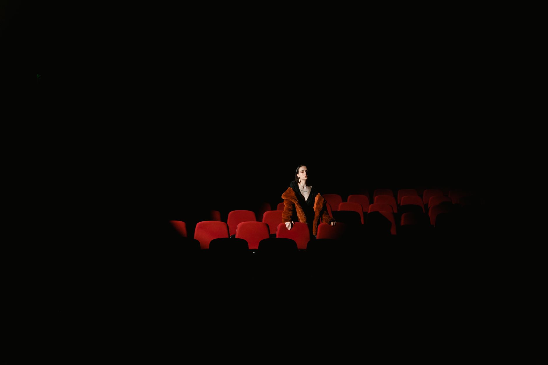 Karanlık bir sinema salonunda film izleyen seyirciler