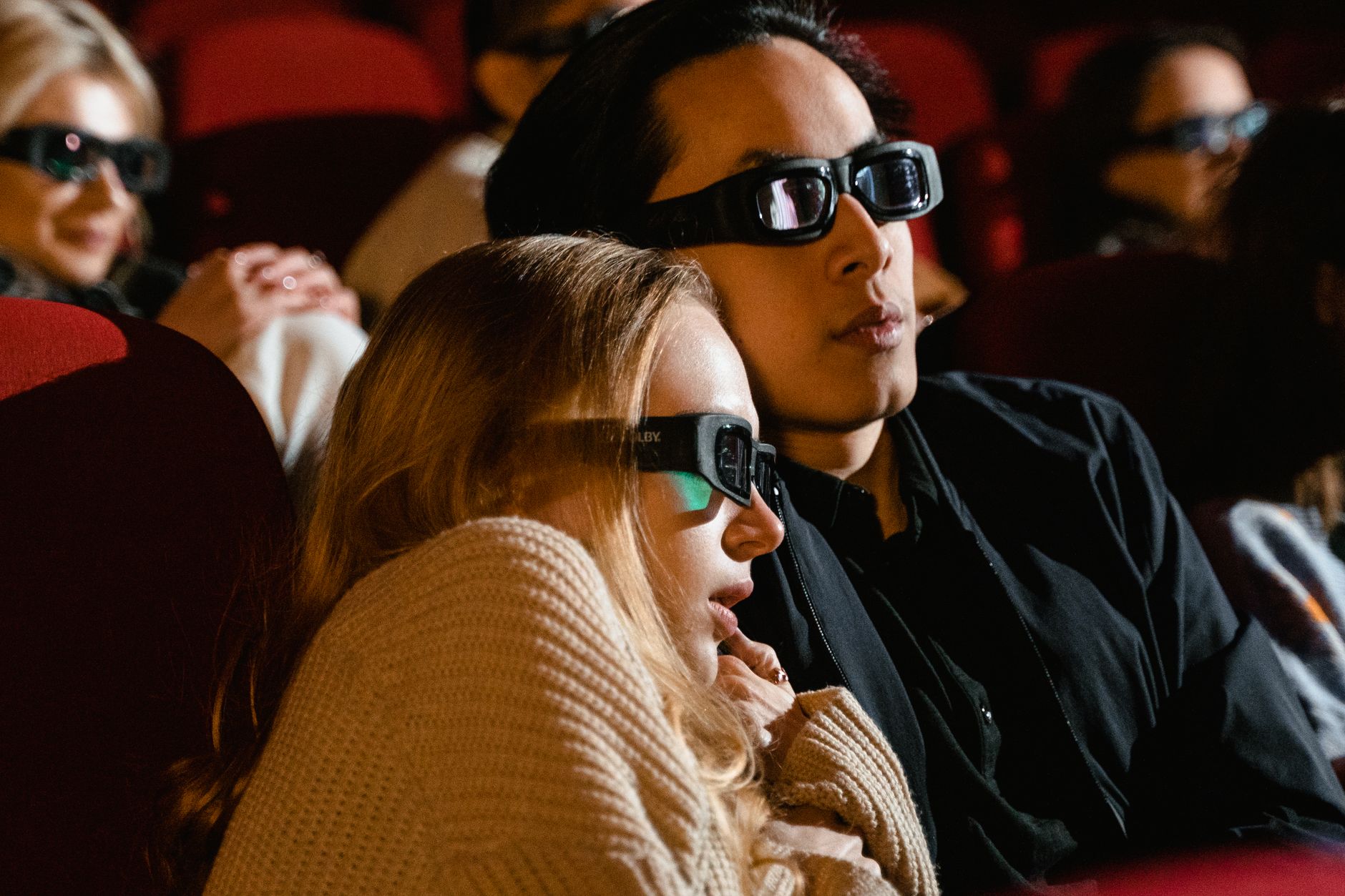 A couple immersed in a 3D movie experience at the cinema, enjoying a thrilling film.