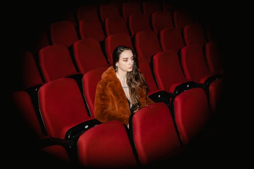 Young Woman Sitting Alone in a Movie Theater