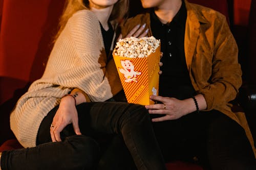 Free Couple with Popcorn on Yellow Tumbler Stock Photo