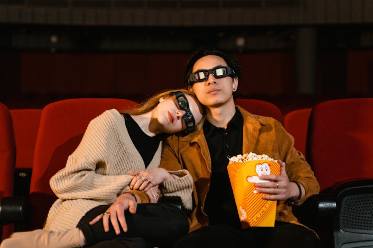 Couple With 3D Glasses And Popcorn In Yellow Tumbler