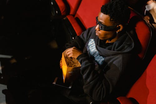 A Man Watching Movie while Wearing 3D Glasses and Hoodie Sweater