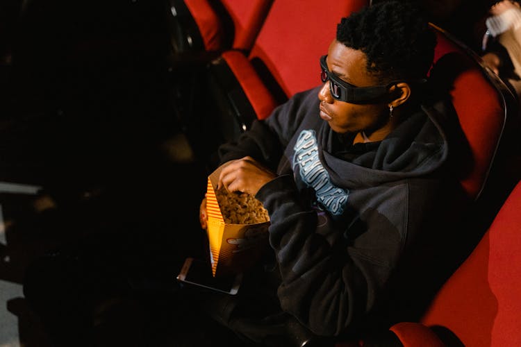 A Man Watching Movie While Wearing 3D Glasses And Hoodie Sweater