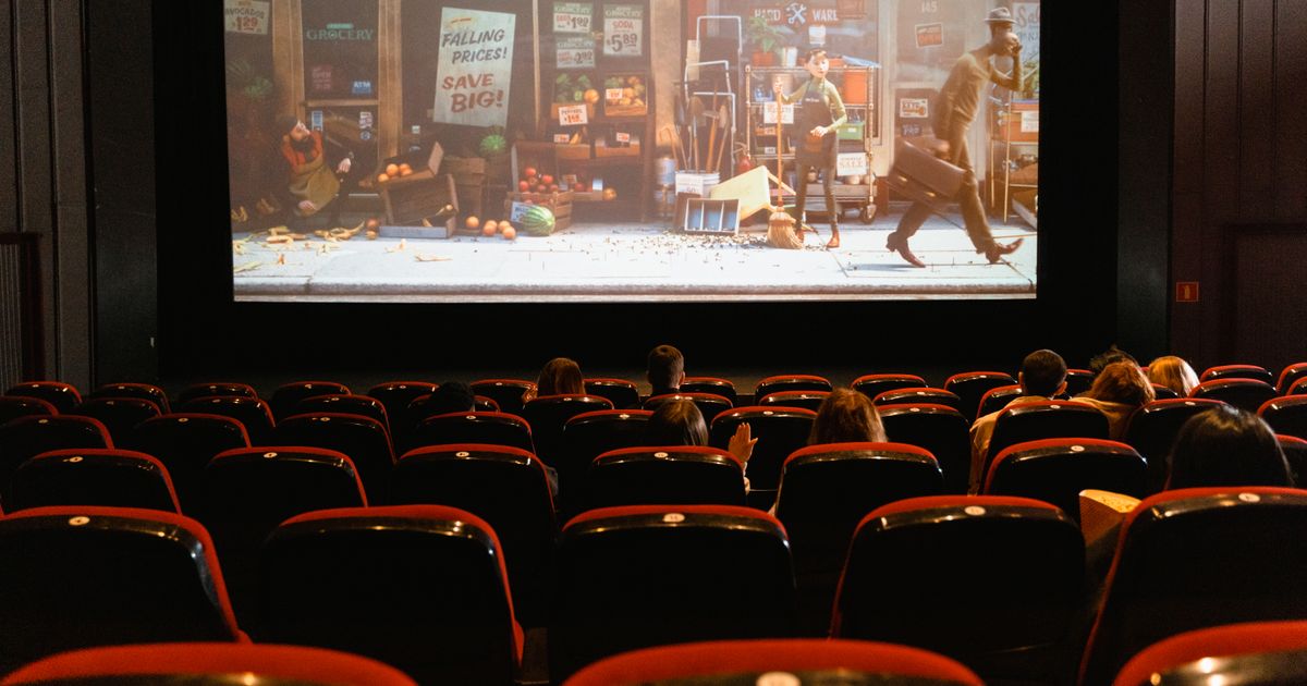 A cozy indoor movie theater showing an animated film to a small audience.