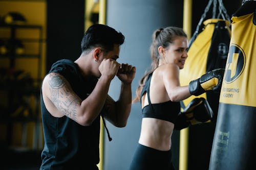 Coach showing punch technique to woman