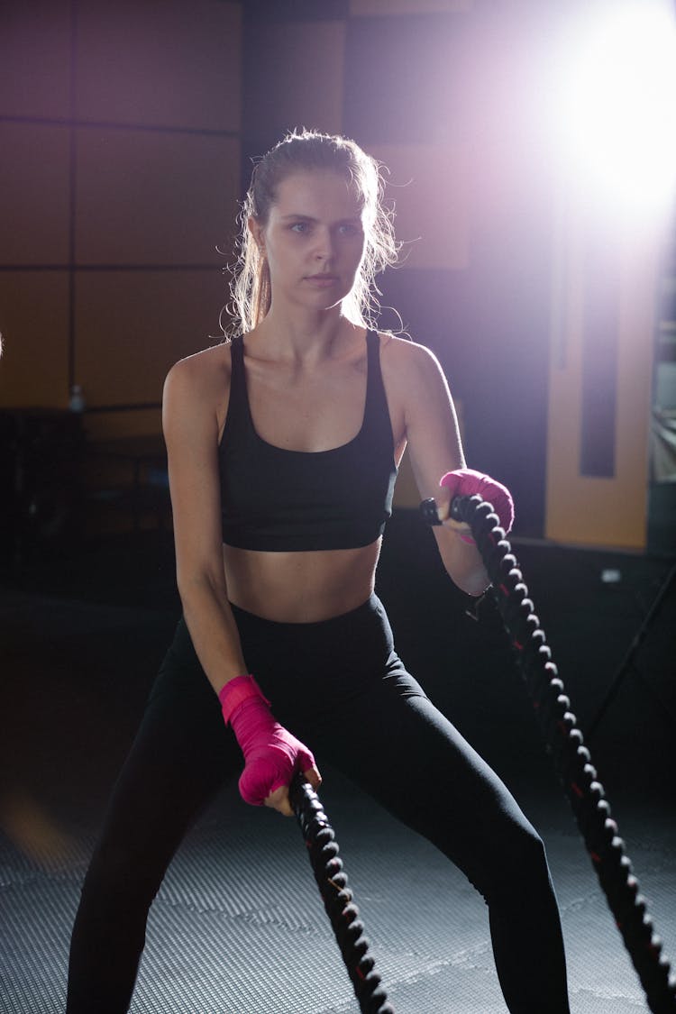 Sportswoman Exercising With Battle Ropes