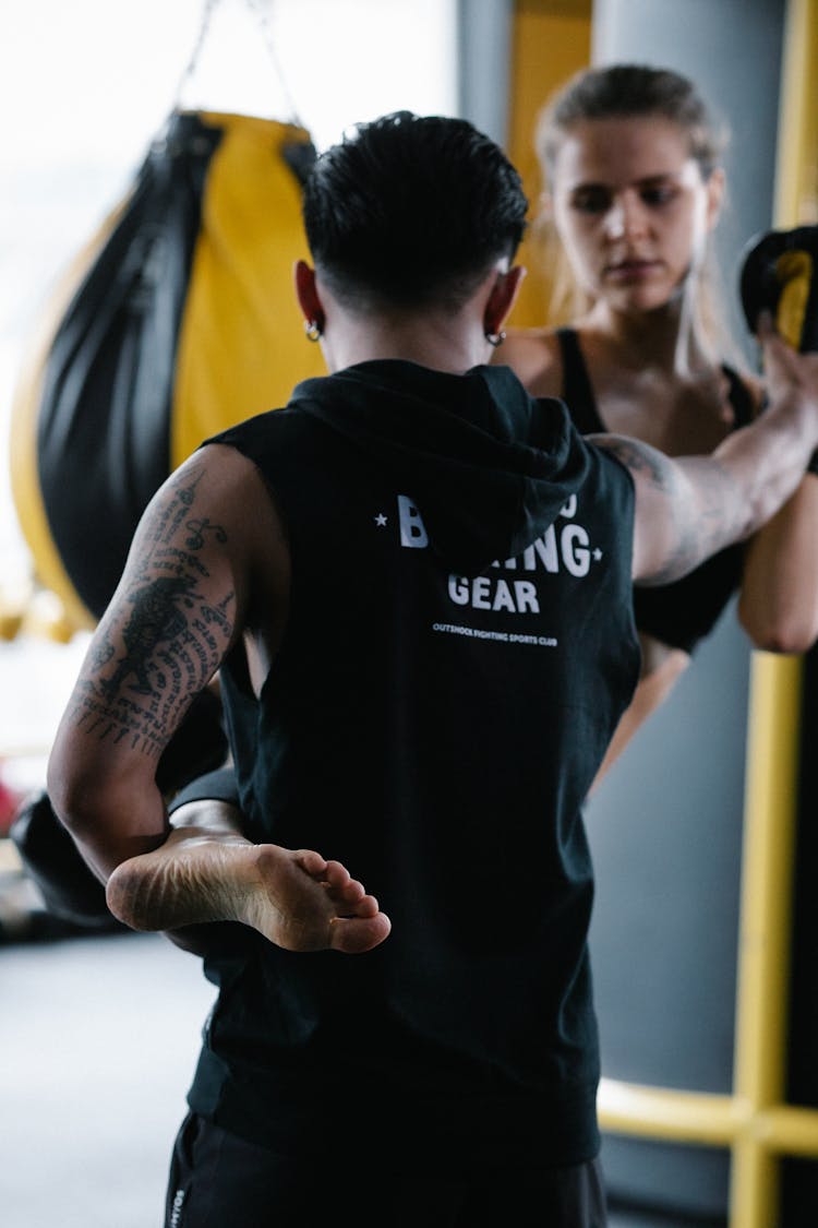 Man Training Woman In Kickboxing