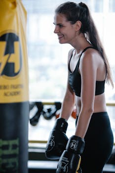 A woman boxer smiling during a workout session in the gym.