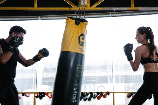 Man Training Woman in Boxing