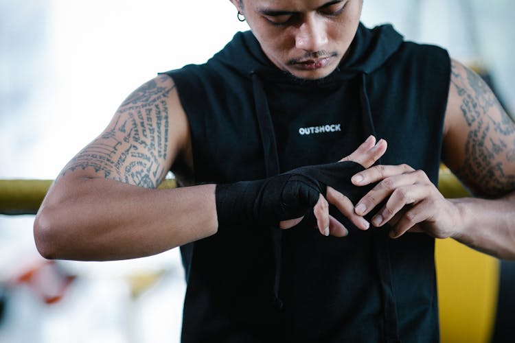 Brutal Ethnic Boxer Bandaging Hand In Gym