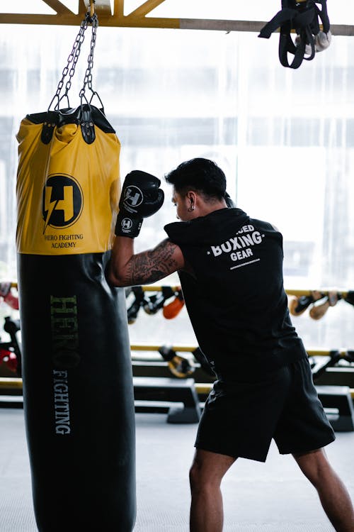Free Fighter doing boxing exercise in light gym Stock Photo