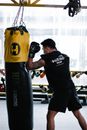 Fighter doing boxing exercise in light gym