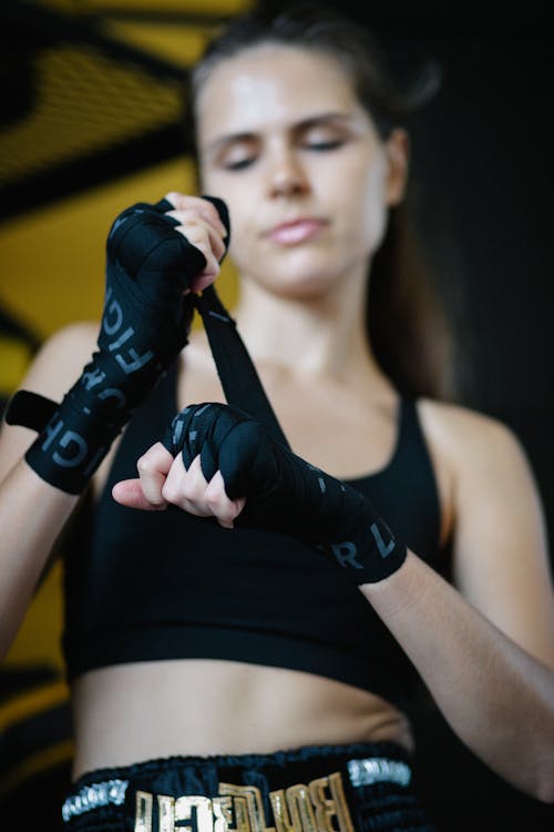 Female boxer wrapping hands before training