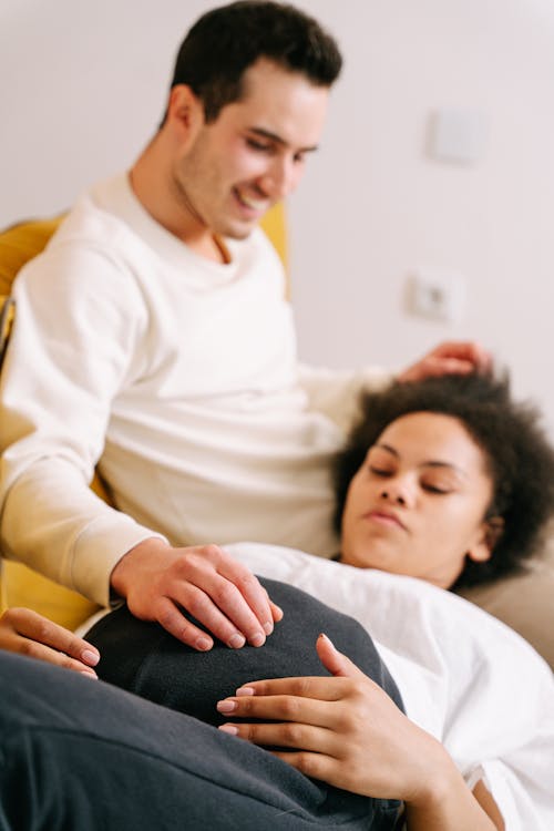 Pregnant Woman Lying Down on the Lap of a Man