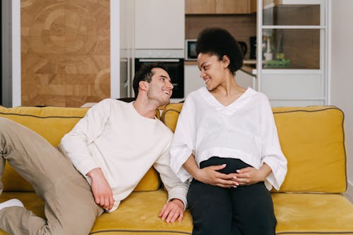 Happy Couple Sitting on Yellow Couch