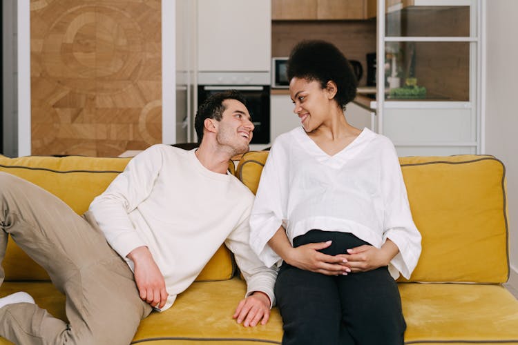 Happy Couple Sitting On Yellow Couch