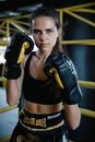 A Woman in Sports Wear Wearing Black Boxing Gloves