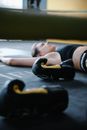 Boxing Gloves Beside a Person Lying on the Floor