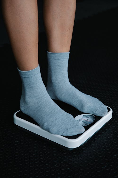 A Person Wearing Gray Socks Standing on a Weighing Scale