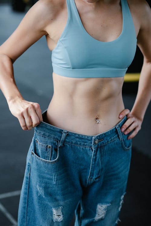 Toned Woman in Loose Pants Showing Diet Results