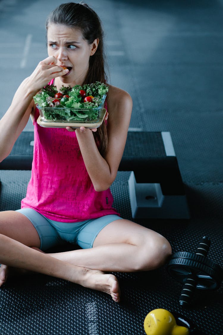 Woman Sitting At The Gym Eating A Salad 